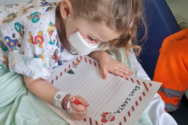Elouise Smith writing a letter to Santa from hospital in December 2023 after the dog attack. 