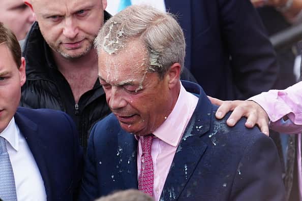 Reform UK party leader Nigel Farage reacts after a woman threw a drink over him, as he launches his election candidacy at Clacton Pier on June 4, 2024 in Clacton-on-Sea, England. The launch follows yesterday's announcement that Nigel Farage will stand as an MP in Clacton at the 4 July general election and takes over from Richard Tice as leader of Reform UK. The Conservative-held seat in Essex was the first to elect a UKIP MP in 2014, a party that Farage founded. (Photo by Carl Court/Getty Images)
