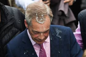 A woman has been charged with assault after a milkshake was thrown at Nigel Farage
